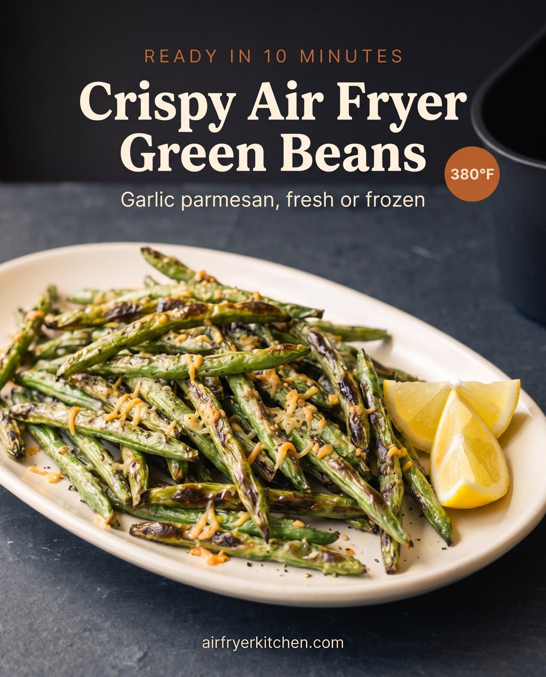 An oval plate of blistered green beans with melted parmesan, cracked pepper and lemon wedges, with the text Crispy Air Fryer Green Beans, garlic parmesan, fresh or frozen, 380°F.